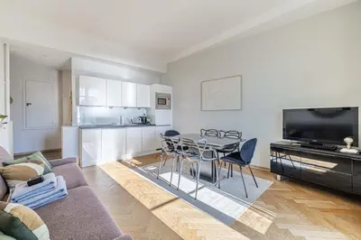 a living room with a couch and a table and chairs at 20 LACROIX - Cozy 2-bedroom apartment with balcony and sea view in Cannes