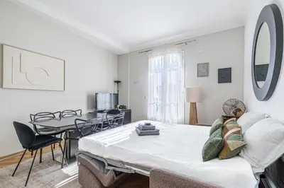 a room with a bed and a table and chairs at 20 LACROIX - Cozy 2-bedroom apartment with balcony and sea view in Cannes