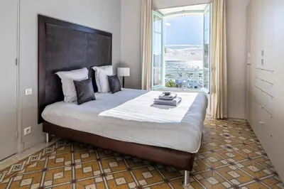 a bedroom with a large bed with a large window at 20 LACROIX - Cozy 2-bedroom apartment with balcony and sea view in Cannes