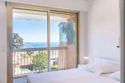 a bedroom with a bed and a large window at Appartement Vue Mer au Palm Beach in Cannes