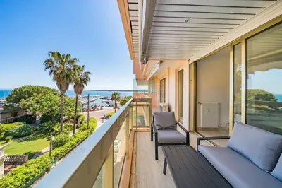 a balcony with a couch and a view of the ocean at Appartement Vue Mer au Palm Beach in Cannes
