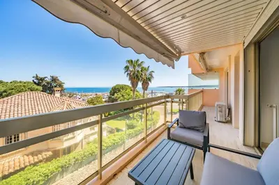a balcony with a chair and a view of the ocean at Appartement Vue Mer au Palm Beach in Cannes