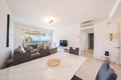a living room with a large white table and chairs at Appartement Vue Mer au Palm Beach in Cannes