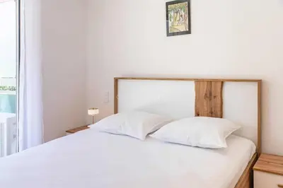 a bedroom with a bed with white sheets and a window at Appartement Vue Mer au Palm Beach in Cannes