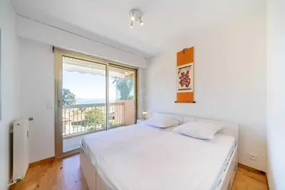 a bedroom with a bed and a large window at Appartement Vue Mer au Palm Beach in Cannes