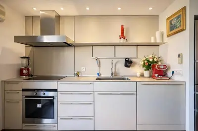 a kitchen with white cabinets and a sink at VERCORS next to the Sea & Beach in Cannes