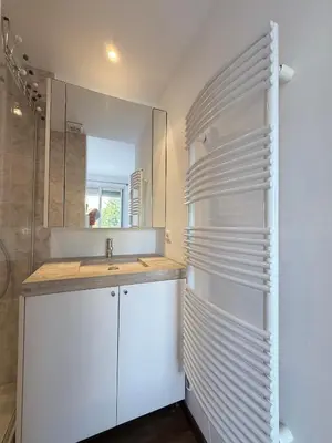 a white bathroom with a sink and a mirror at VERCORS next to the Sea & Beach in Cannes