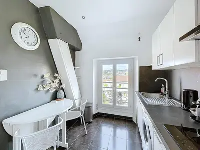 a kitchen with a sink and a clock on the wall at Le Week 5 min Palais 3 bedrooms WIFI in Cannes