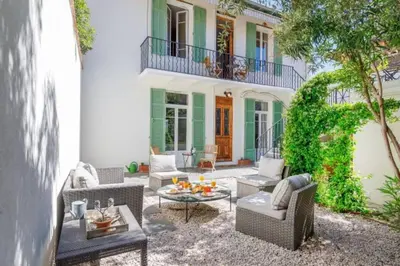 a patio with chairs and a table in front of a building at Maison Noble in Cannes
