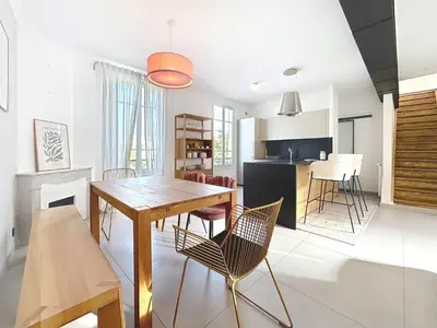 a kitchen and dining room with a wooden table and chairs at Maison Noble in Cannes