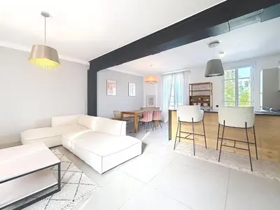 a living room with a white couch and a table at Maison Noble in Cannes
