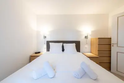 a bedroom with a white bed with two pillows at Ground-Floor 2 Br - Near Centre & Beaches in Cannes