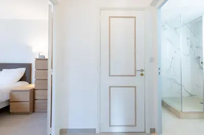 a bedroom with a white door and a bed at Ground-Floor 2 Br - Near Centre & Beaches in Cannes