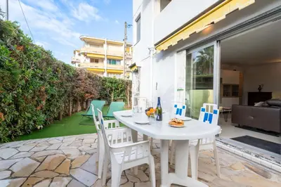 a white table and chairs on the patio of a house at Ground-Floor 2 Br - Near Centre & Beaches in Cannes