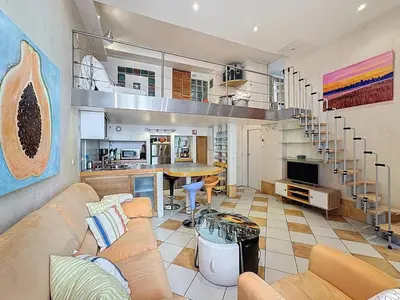 a living room with a couch and a spiral staircase at Cosy Short-Term Rental in Cannes in Cannes