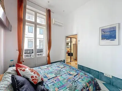 a bedroom with a bed and a large window at Cosy Short-Term Rental in Cannes in Cannes