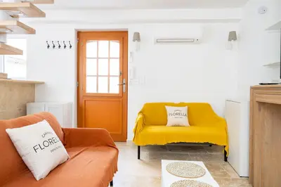 a living room with a couch and a yellow chair at TINY HOUSE en duplex avec terrasse in Cannes