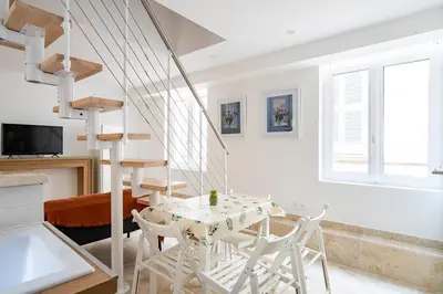 a white dining room with a table and chairs at TINY HOUSE en duplex avec terrasse in Cannes