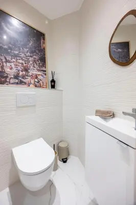 a white bathroom with a toilet and a sink at Esprit Chic - Elégant & central près du Palais in Cannes