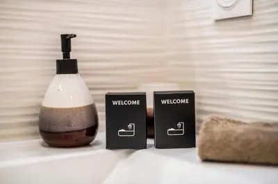 a bathroom counter with two black candles and a bottle at Esprit Chic - Elégant & central près du Palais in Cannes