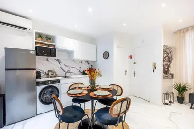 a kitchen with a table and chairs in a room at Esprit Chic - Elégant & central près du Palais in Cannes