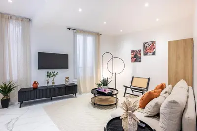 a living room with a couch and a tv at Esprit Chic - Elégant & central près du Palais in Cannes