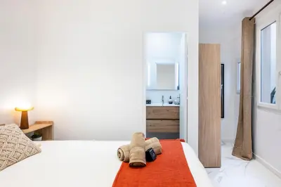 a bedroom with a bed with a teddy bear on a red blanket at Esprit Chic - Elégant & central près du Palais in Cannes