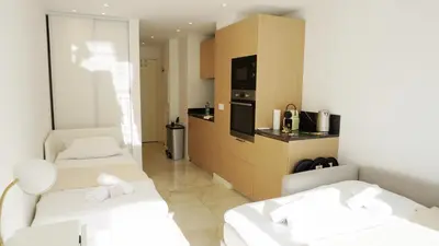 a small room with two beds and a kitchen at Proche gare et commerces, 5min plage, 4 personnes - Palmazur Vacances in Cannes