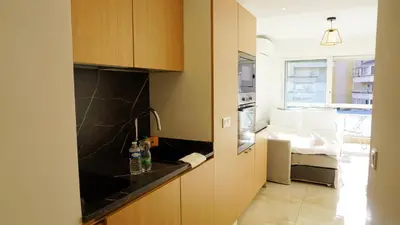 a kitchen with wooden cabinets and a sink at Proche gare et commerces, 5min plage, 4 personnes - Palmazur Vacances in Cannes