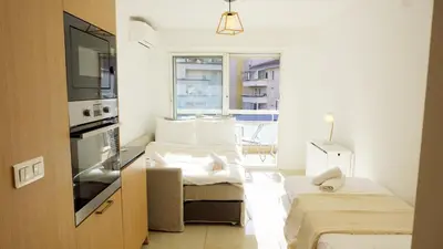 a small room with two beds and a window at Proche gare et commerces, 5min plage, 4 personnes - Palmazur Vacances in Cannes