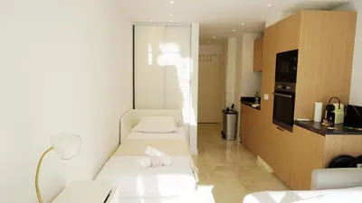 a small room with two beds and a kitchen at Proche gare et commerces, 5min plage, 4 personnes - Palmazur Vacances in Cannes