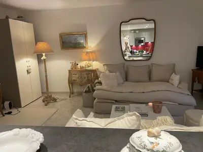 a living room with a couch and a mirror at Appartement au centre de Cannes à deux pas du festival in Cannes