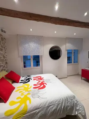 a bedroom with a large bed and two windows at Magnifique studio proche palais des festivals in Cannes
