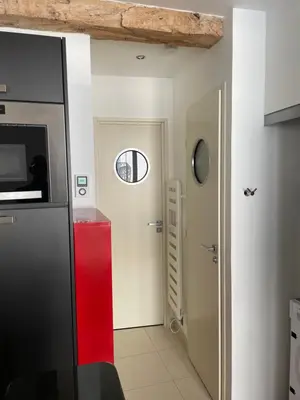 a kitchen with a red door and a window at Magnifique studio proche palais des festivals in Cannes