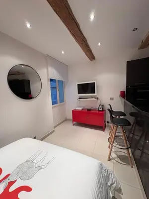 a bedroom with a bed and a television and a chair at Magnifique studio proche palais des festivals in Cannes