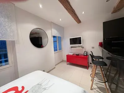 a bedroom with a red cabinet and a mirror at Magnifique studio proche palais des festivals in Cannes
