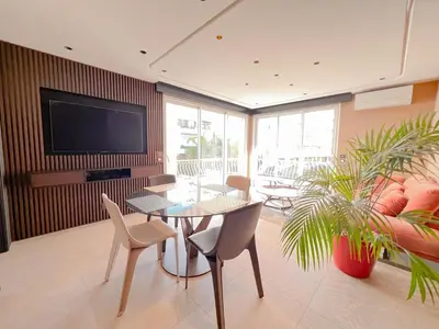 a living room with a table and chairs and a tv at Croisette Luxury in Cannes
