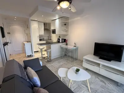 a living room with a couch and a kitchen at Central Studio in Cannes Near The Martinez - 2351 in Cannes