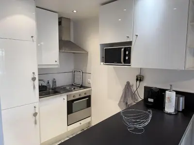 a kitchen with white cabinets and a black counter top at Central Studio in Cannes Near The Martinez - 2351 in Cannes