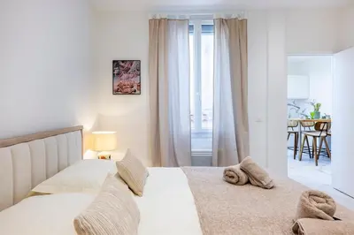 a white bedroom with a bed and a dining room at Esprit Bohème - Elegant & central près du Palais in Cannes