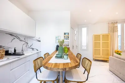 a kitchen with a wooden table and chairs at Esprit Bohème - Elegant & central près du Palais in Cannes