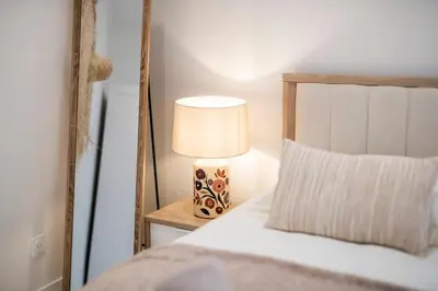 a bedroom with a bed with a lamp on a night stand at Esprit Bohème - Elegant & central près du Palais in Cannes