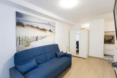 a blue couch in a living room with a painting at Studio near Palais des Festivals in Cannes