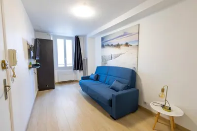 a living room with a blue couch in a room at Studio near Palais des Festivals in Cannes