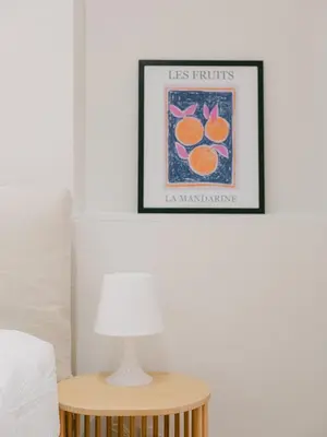 a table with a lamp and a picture on the wall at La Mouette-appartement au Vieux Port in Cannes