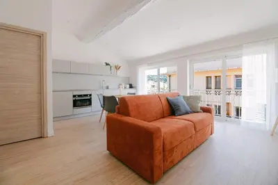 a living room with an orange couch and a kitchen at La Mouette-appartement au Vieux Port in Cannes