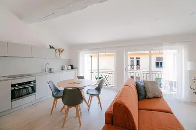 a living room with a couch and a table with chairs at La Mouette-appartement au Vieux Port in Cannes
