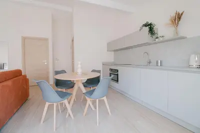 a kitchen with a table and chairs and a couch at La Mouette-appartement au Vieux Port in Cannes