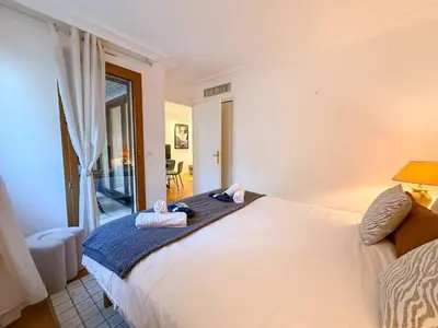 a table and chairs in a room with a balcony at Central Cannes Apartment with Private Terrace - 5 Min to Croisette in Cannes
