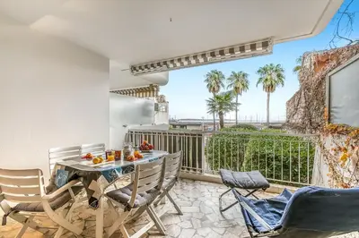 a room with a table and chairs and a balcony at Cannes Sea View - Port du Moure Rouge - Happy Rentals in Cannes
